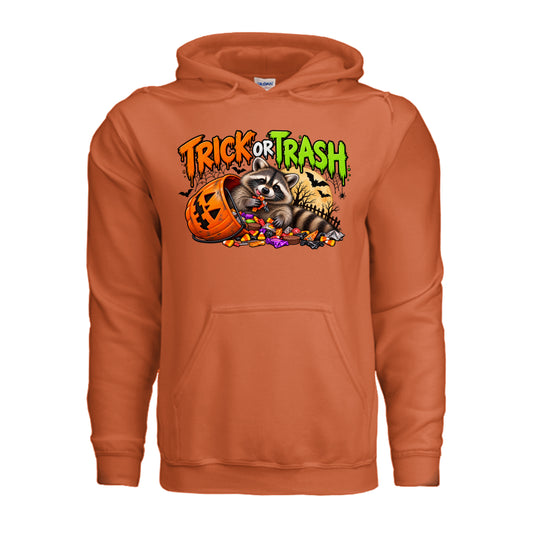 Orange Trick or Trash Halloween graphic with a raccoon, orange pumpkin candy bucket, candy, glowing moon, bats, and spooky trees.